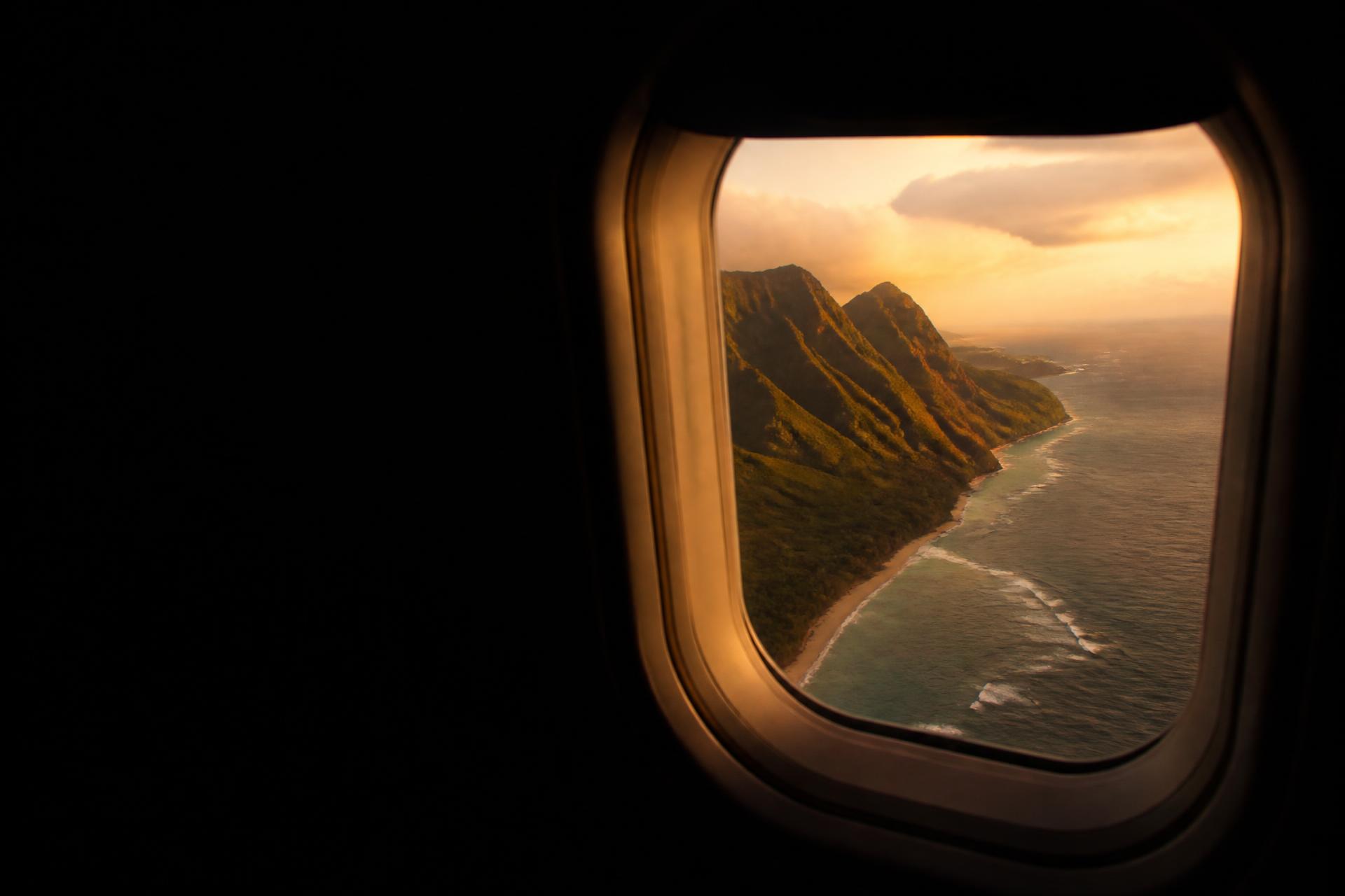 View of a tropical coastline from an aircraft window at golden hour